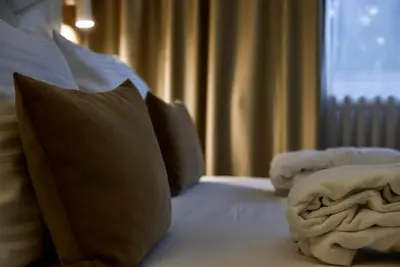 a bedroom with a bed with pillows and a window at Hotel Sumadija in Belgrade