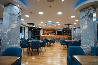 a dining room with blue chairs and tables at Hotel Sumadija in Belgrade