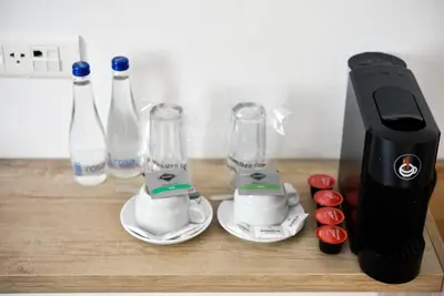 a counter with a blender and two cups and bottles at Hotel Sumadija in Belgrade
