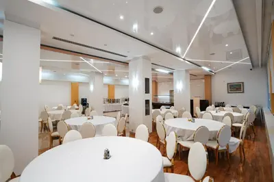 a banquet hall with white tables and chairs at Hotel Sumadija in Belgrade