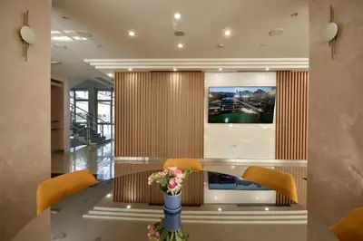 a dining room with a television and a table with chairs at Hotel Sumadija in Belgrade