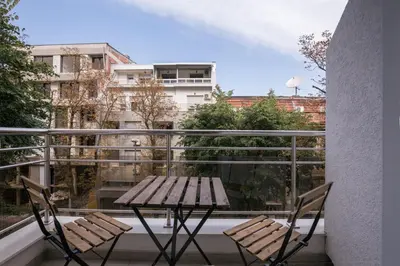 a table and chairs on a balcony with a view of a city at Belgrade apartment Skadarlija in Belgrade