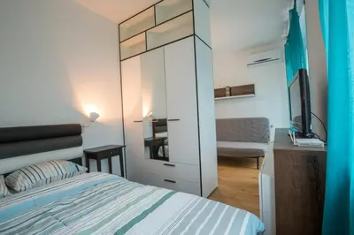 a bedroom with a bed and a tv and a desk at Belgrade apartment Skadarlija II in Belgrade