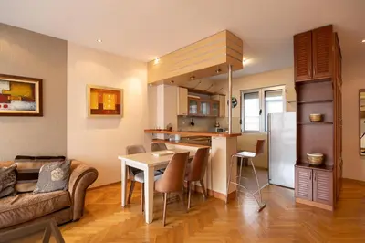 a kitchen and living room with a table and a couch at Belgrade Center Apartment Lux II in Belgrade