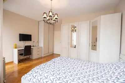 a bedroom with a bed and a desk and a television at Belgrade Center Apartment Lux II in Belgrade