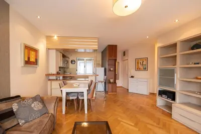 a living room with a table and a kitchen at Belgrade Center Apartment Lux II in Belgrade