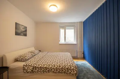 a bedroom with a bed and a blue curtain at Belgrade Center Apartment Skadarlija III in Belgrade