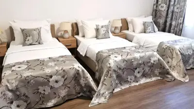 a bedroom with two beds with white and gray blankets at Hotel N in Belgrade