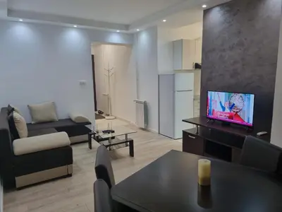 a living room with a couch and a tv on a table at stan Slavija in Sajmište