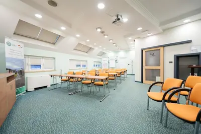 a classroom with tables and chairs in a room at Kopernikus Hotel Prag in Belgrade