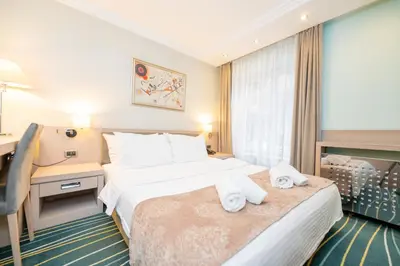 a hotel room with a bed and a desk at Kopernikus Hotel Prag in Belgrade