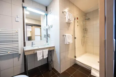 a bathroom with a shower and a sink and a toilet at Kopernikus Hotel Prag in Belgrade