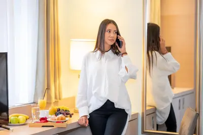 a woman talking on a cell phone in front of a mirror at Kopernikus Hotel Prag in Belgrade