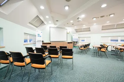 a classroom with tables and chairs and a whiteboard at Kopernikus Hotel Prag in Belgrade