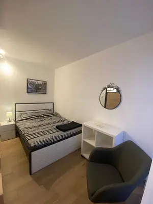 a bedroom with a bed and a chair and a mirror at Sancho Leone in Belgrade