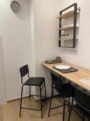 a kitchen with a table and chairs and a clock at Sancho Leone in Belgrade