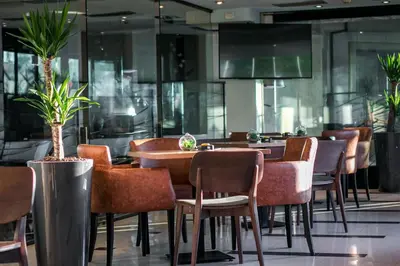 a restaurant with tables and chairs and plants at Design Hotel Mr President in Belgrade