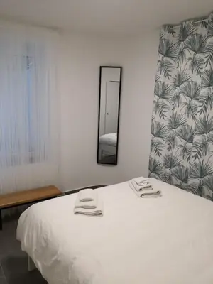 a white bed in a room with a mirror at Bibi Zahumska apartman in Belgrade