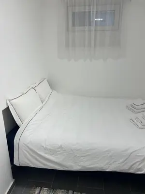 a white bed in a room with a window at Bibi Zahumska apartman in Belgrade