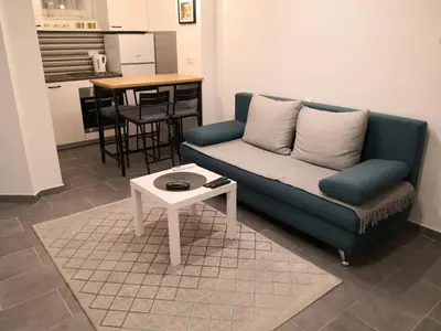 a living room with a blue couch and a table at Bibi Zahumska apartman in Belgrade