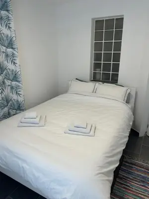 a white bed with two towels on top of it at Bibi Zahumska apartman in Belgrade