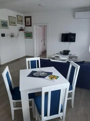 a white table with two blue chairs and a white table at Apartman Jass in Stari Banovci