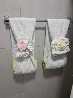 two towels with roses on them hanging on a wall at Apartman Jass in Stari Banovci