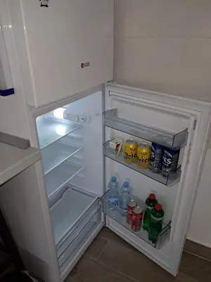 an open refrigerator with water bottles and drinks in it at Apartman Jass in Stari Banovci