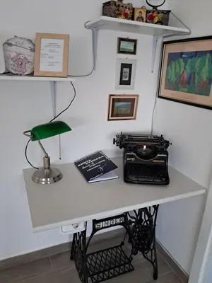 a desk with a typewriter and a phone on it at Apartman Jass in Stari Banovci