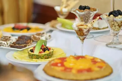 a table with plates of desserts and glasses of food at Hotel Orasac in Belgrade