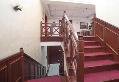 a staircase in a house with wooden railings and red carpet at Hotel Orasac in Belgrade