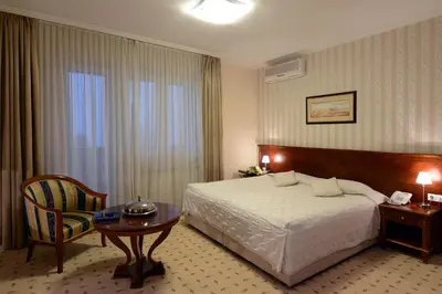a hotel room with a bed and a table and a chair at Hotel Orasac in Belgrade