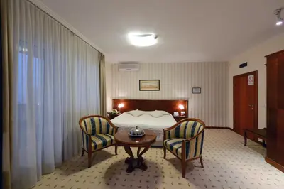 a hotel room with a bed and two chairs at Hotel Orasac in Belgrade