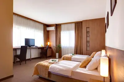 a hotel room with two beds and a desk at Hotel Knezevina in Vranić
