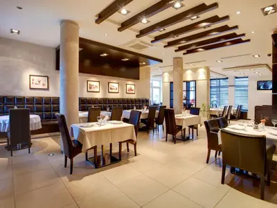 a dining room with tables and chairs in a restaurant at Hotel Knezevina in Vranić