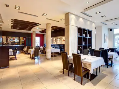 a restaurant with tables and chairs and a bar at Hotel Knezevina in Vranić