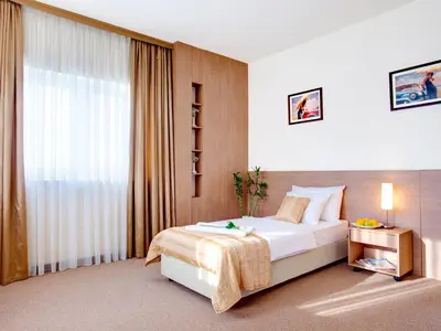 a hotel room with a bed and a large window at Hotel Knezevina in Vranić