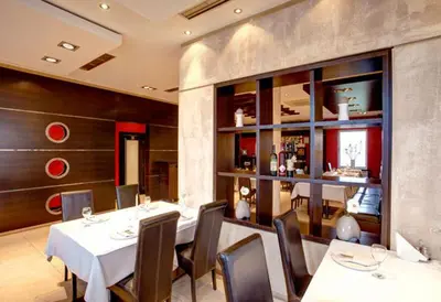 a dining room with tables and chairs and a bar at Hotel Knezevina in Vranić