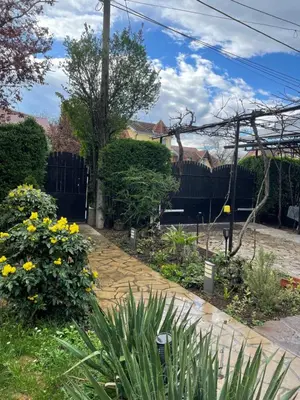 a garden with yellow flowers and a wooden walkway at 5min Airport in Surčin