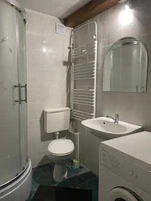 a white bathroom with a toilet and a sink at 5min Airport in Surčin