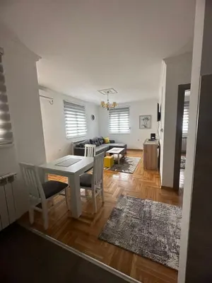a dining room and living room with a table and chairs at Port 2 in Belgrade