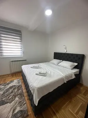 a bedroom with a large bed with a black headboard at Port 2 in Belgrade