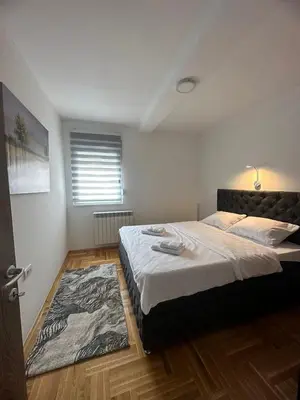 a bedroom with a large bed and a rug at Port 2 in Belgrade
