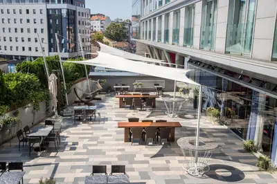 an outdoor patio with tables and chairs and buildings at Nobel Zira Hotel in Belgrade