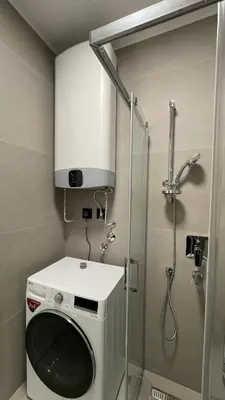 a washing machine in a bathroom with a shower at Moderna Vračar in Belgrade