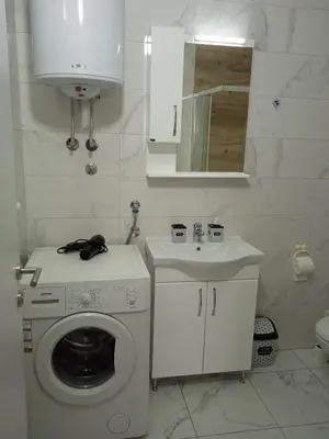 a white bathroom with a washing machine and a sink at Happy Day in Obrenovac