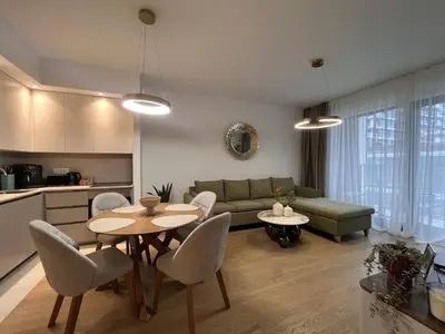 a living room with a couch and a table and chairs at ZIGZAG Belgrade Waterfront Terra in Belgrade
