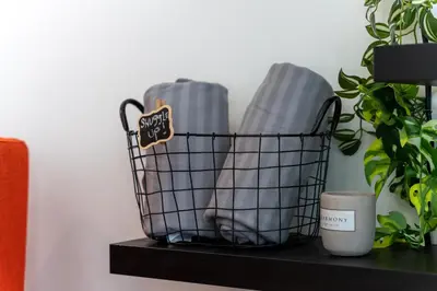 a basket on a shelf with a candle and a plant at ZIGZAG Belgrade Waterfront Terra in Belgrade