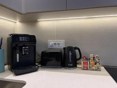 a kitchen counter with a coffee maker and a microwave at ZIGZAG Belgrade Waterfront Terra in Belgrade