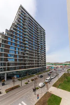a large building with cars parked in a parking lot at ZIGZAG Belgrade Waterfront Terra in Belgrade